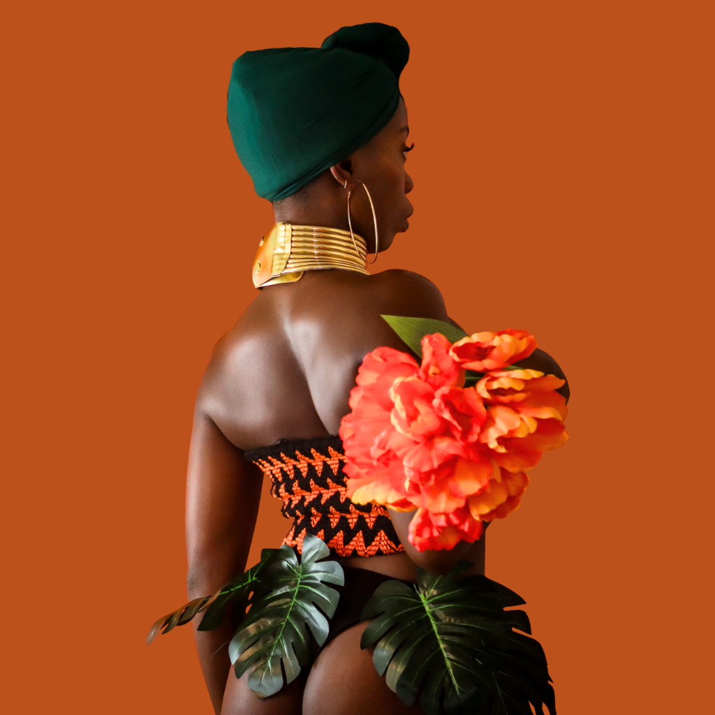 Soulful Baddie model holding orange flowers, symbolizing healing, self-love, and feminine strength in wellness and fitness lifestyle.